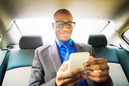 A dealership salesperson doing a video chat while he is in the back of a car