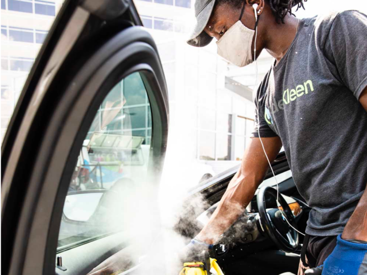 A service employee using specialized cleaning equipment to sanitize a vehicle for a test drive or after a service and repair appointment
