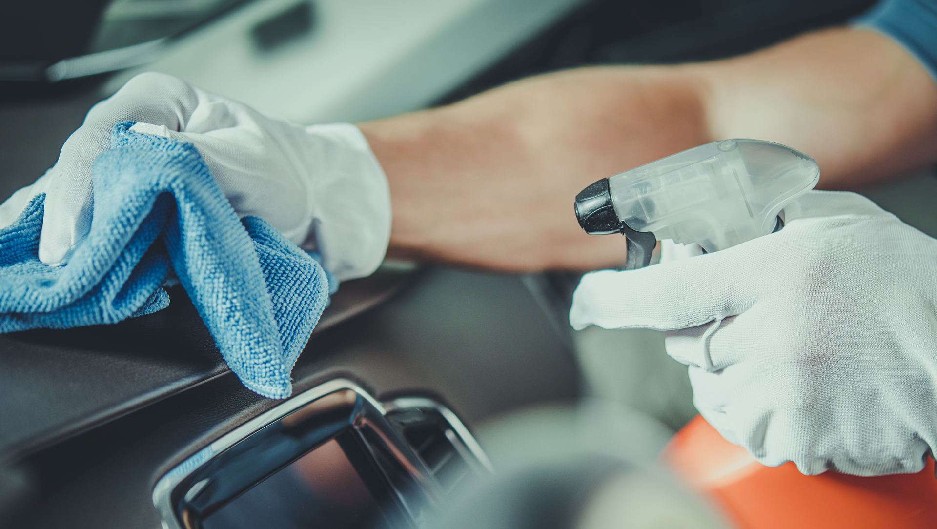 technician spraying RideKleen vehicle disinfectant, cleaning a car